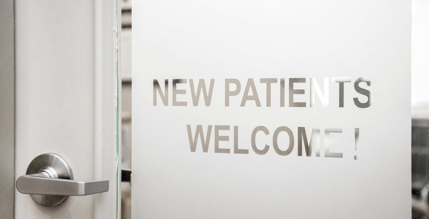 Door with sign saying "new patients welcome"
