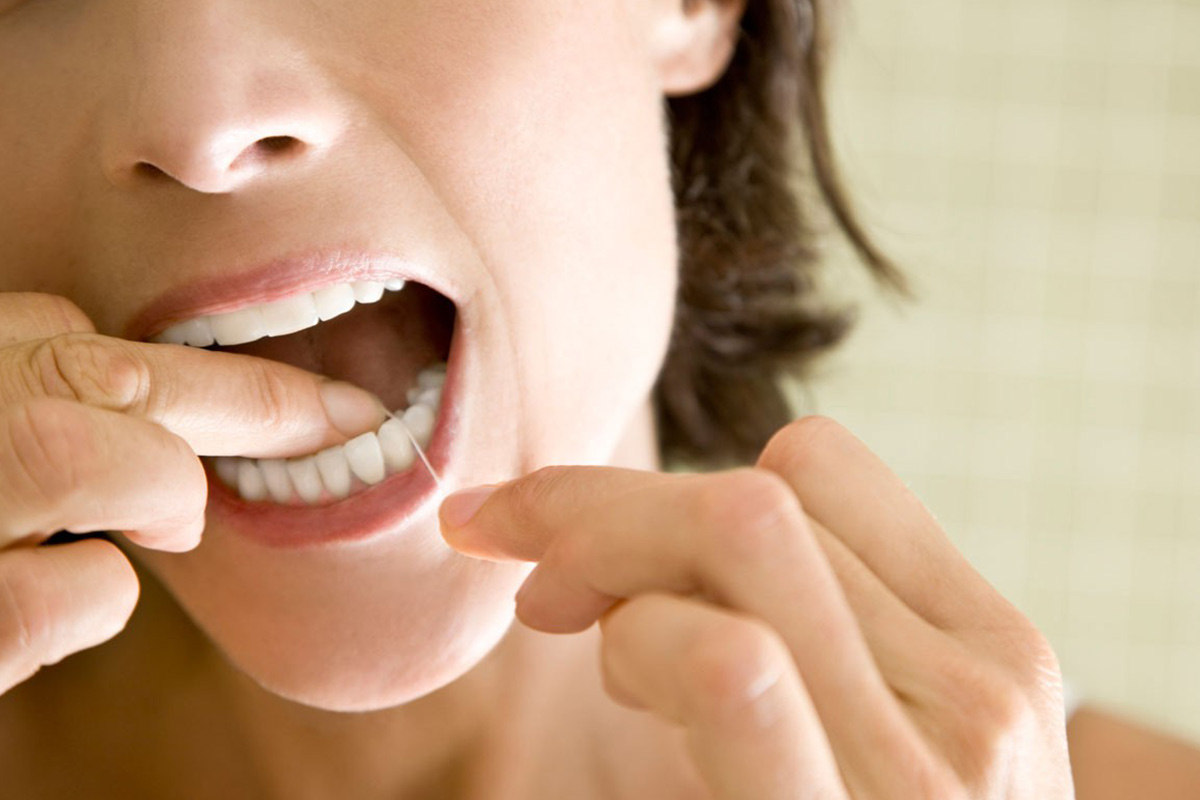 Person flossing between teeth